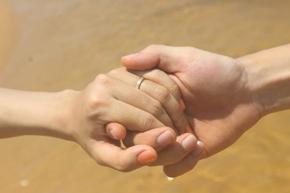 Close up of two people holding hands